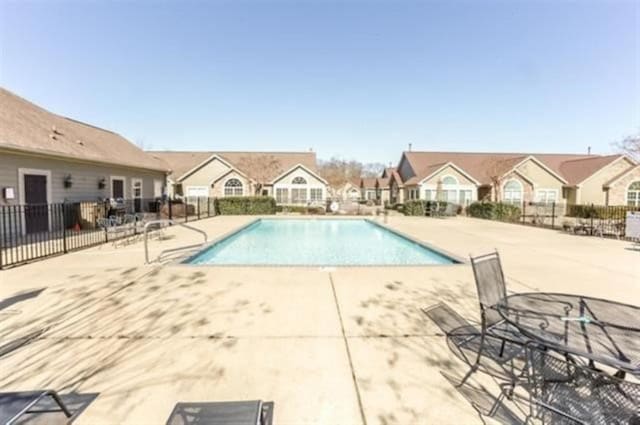 pool with a residential view, fence, and a patio