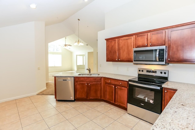 kitchen with vaulted ceiling, a peninsula, decorative light fixtures, stainless steel appliances, and a sink