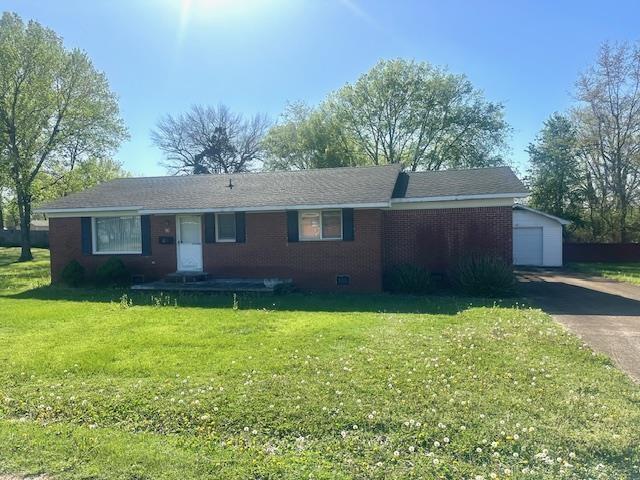 ranch-style home with an outbuilding, concrete driveway, a front lawn, and brick siding