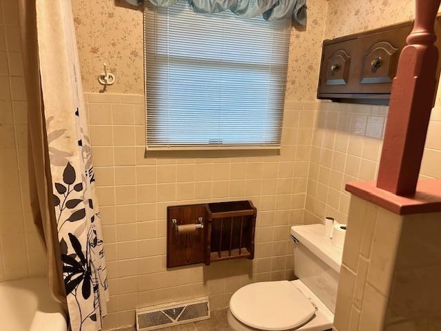 full bathroom with visible vents, wallpapered walls, toilet, and wainscoting