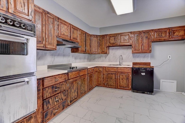 kitchen with a sink, light countertops, under cabinet range hood, marble finish floor, and black appliances