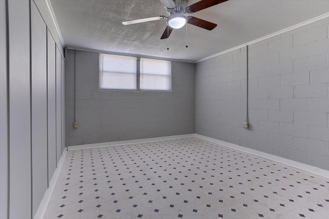 interior space featuring tile patterned floors, a ceiling fan, a textured ceiling, and concrete block wall
