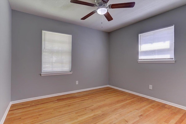 unfurnished room with wood finished floors, ceiling fan, and baseboards