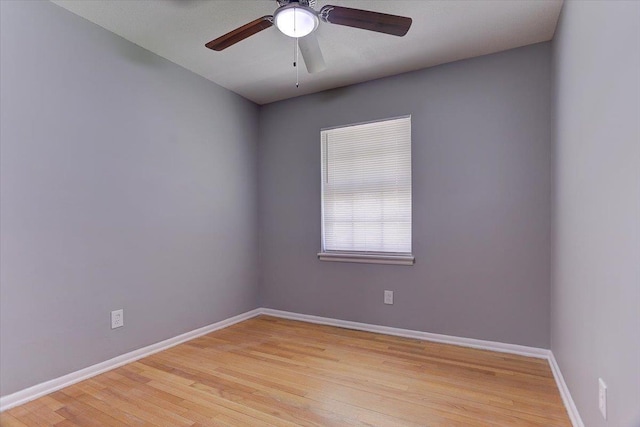unfurnished room with light wood finished floors, baseboards, and a ceiling fan