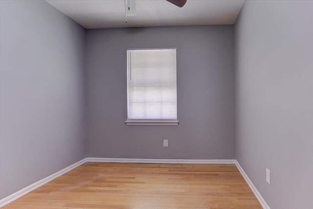 empty room featuring light wood-style flooring, baseboards, and a ceiling fan