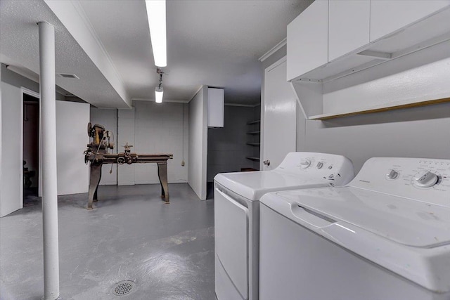 laundry room with visible vents, independent washer and dryer, concrete block wall, and cabinet space