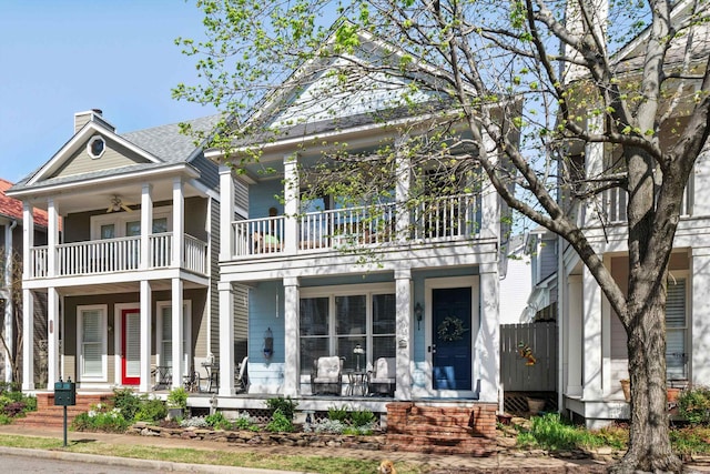 1005 River Currents Dr, Memphis, TN 38103 - greek revival house featuring a chimney, covered porch, a ceiling fan, and a balcony