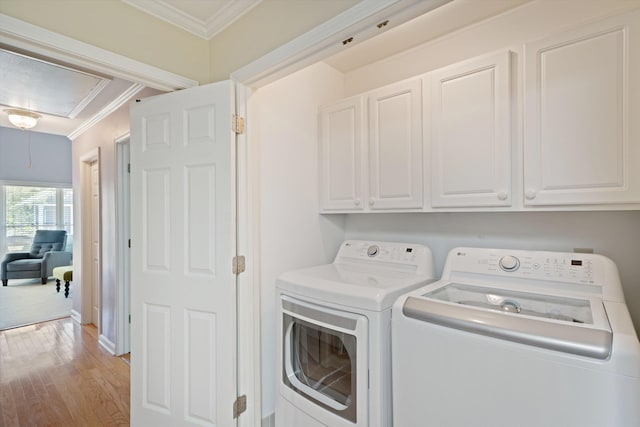 1005 River Currents Dr, Memphis, TN 38103 - washroom featuring light wood-type flooring, ornamental molding, attic access, independent washer and dryer, and cabinet space