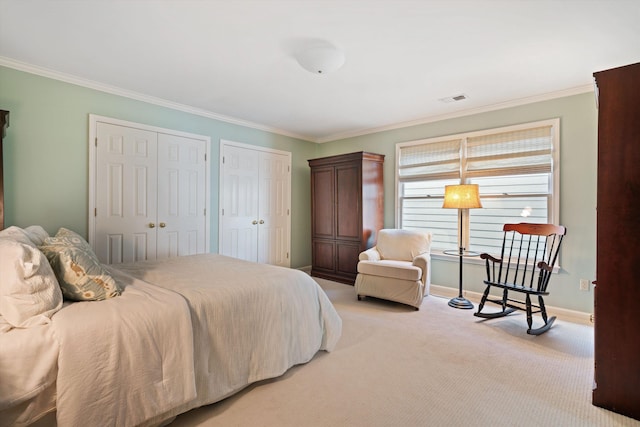 1005 River Currents Dr, Memphis, TN 38103 - bedroom featuring two closets, crown molding, visible vents, light carpet, and baseboards