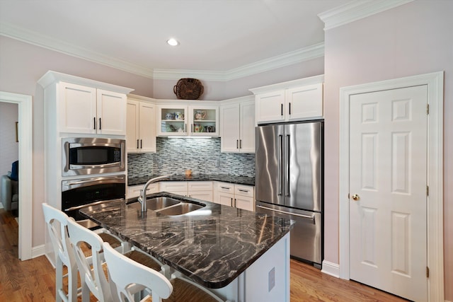 1005 River Currents Dr, Memphis, TN 38103 - kitchen with light wood finished floors, a sink, white cabinets, and stainless steel appliances