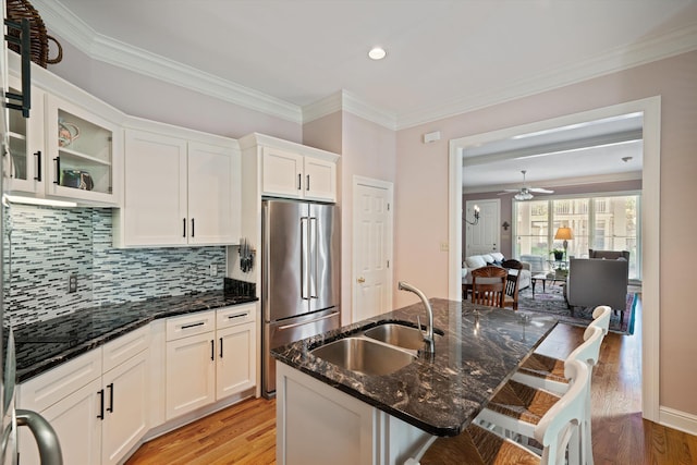 1005 River Currents Dr, Memphis, TN 38103 - kitchen with white cabinetry, light wood-style floors, dark stone counters, high end refrigerator, and a sink