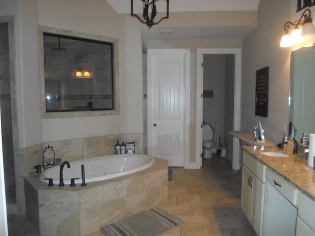 bathroom with a tile shower, a garden tub, vanity, and toilet
