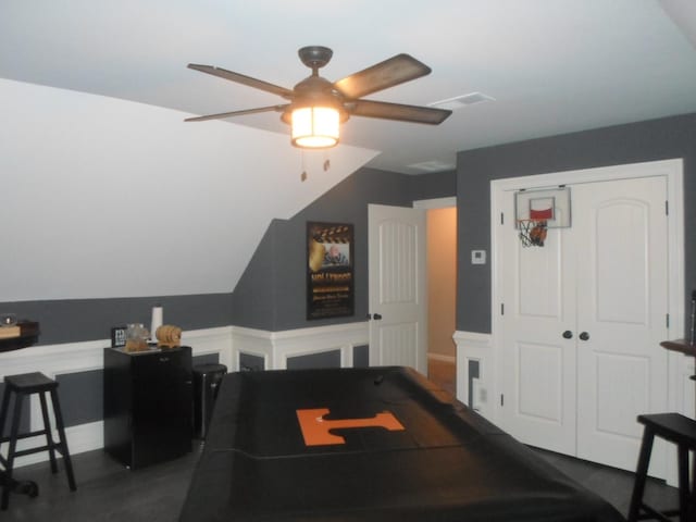 rec room with visible vents, ceiling fan, and vaulted ceiling