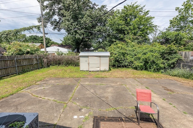 view of patio / terrace with an outbuilding, a fenced backyard, and a shed