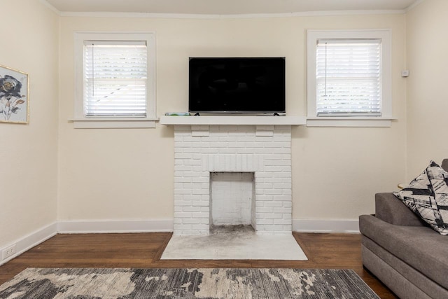living area with wood finished floors, baseboards, and ornamental molding