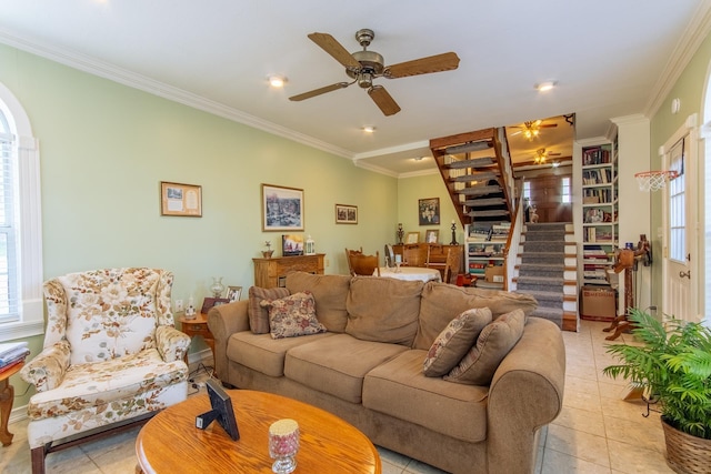 living area with crown molding, light tile patterned flooring, a ceiling fan, and stairway