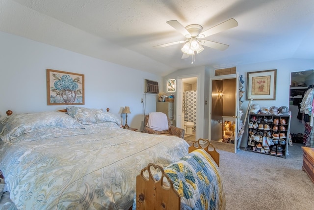 carpeted bedroom with lofted ceiling, a closet, connected bathroom, a wall unit AC, and ceiling fan
