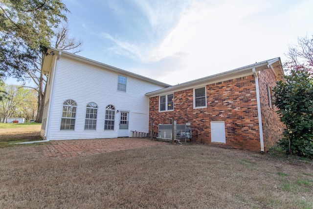 back of property with a patio area, brick siding, and a lawn