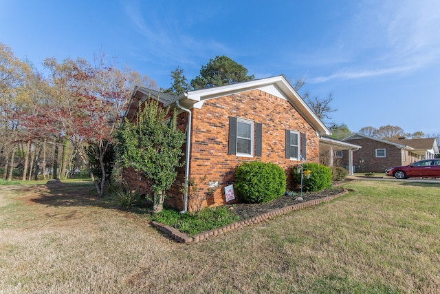 view of home's exterior featuring a yard and brick siding