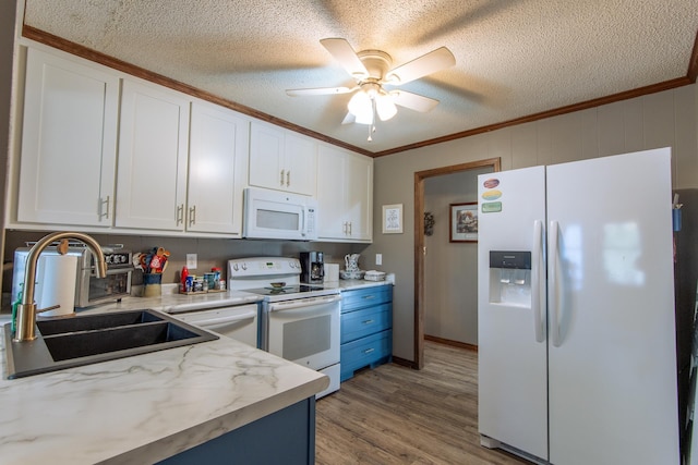 kitchen featuring a sink, ornamental molding, white cabinets, and white appliances
