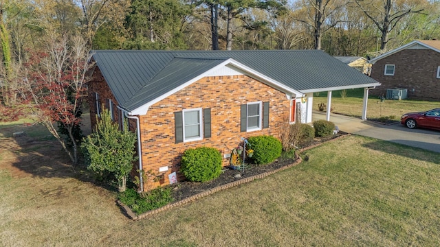 view of front facade with a standing seam roof, metal roof, a front lawn, brick siding, and driveway