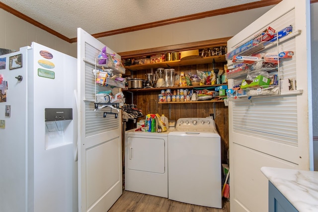 clothes washing area featuring washer and dryer, laundry area, light wood-style floors, crown molding, and a textured ceiling