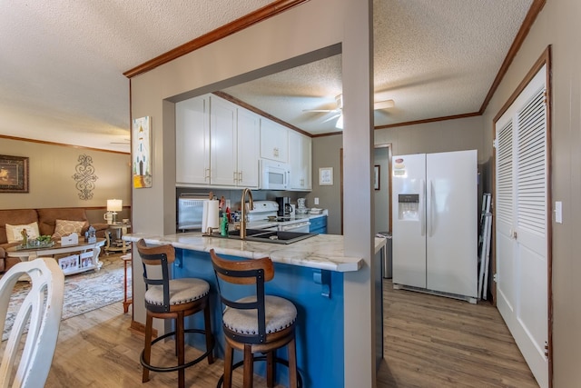 kitchen featuring ornamental molding, white appliances, and wood finished floors