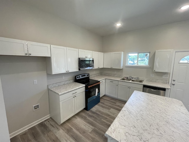 kitchen with white cabinetry, dark wood finished floors, appliances with stainless steel finishes, and a sink