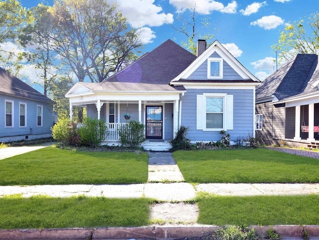 view of front of home with a shingled roof, a porch, a chimney, and a front lawn