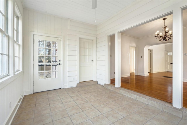 interior space with arched walkways and a chandelier