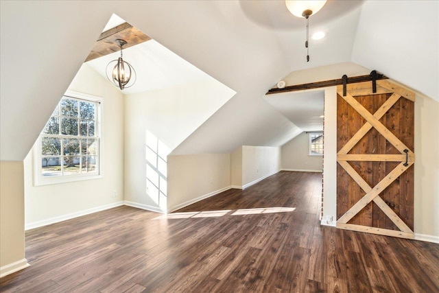 additional living space featuring baseboards, vaulted ceiling, a chandelier, and wood finished floors