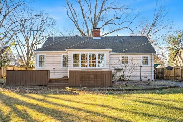 rear view of property featuring crawl space, a yard, fence, and a chimney