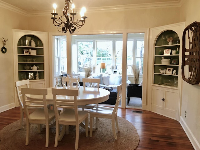 dining area with a notable chandelier, baseboards, ornamental molding, and dark wood finished floors