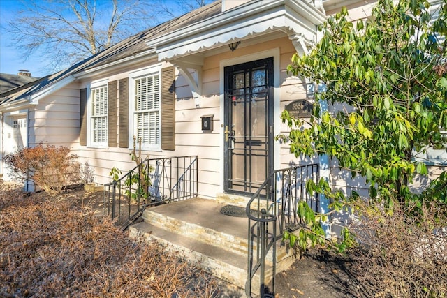 property entrance featuring roof with shingles