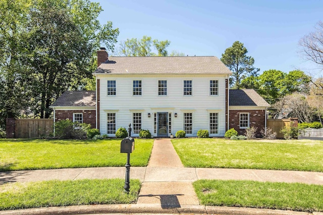 4252 Heatherwood Ln, Memphis, TN 38117 - colonial house with brick siding, fence, a front yard, and a chimney