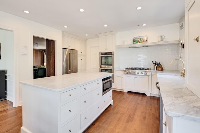 4252 Heatherwood Ln, Memphis, TN 38117 - kitchen featuring a sink, appliances with stainless steel finishes, light wood-style floors, and open shelves