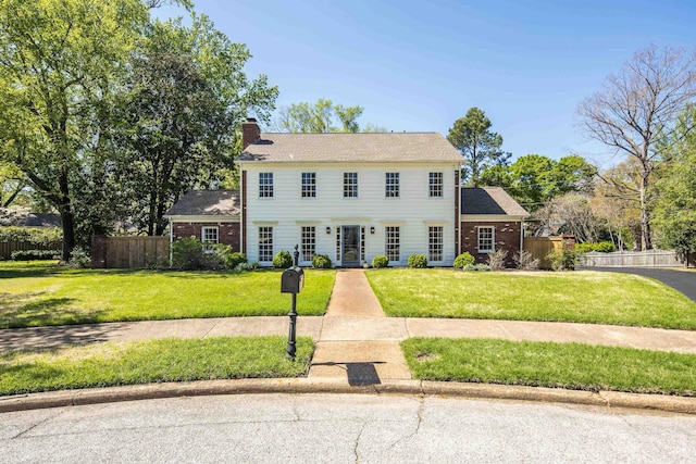 4252 Heatherwood Ln, Memphis, TN 38117 - colonial house featuring a front lawn, fence, and a chimney