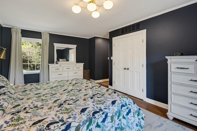 4252 Heatherwood Ln, Memphis, TN 38117 - bedroom with baseboards, dark wood finished floors, crown molding, and an inviting chandelier