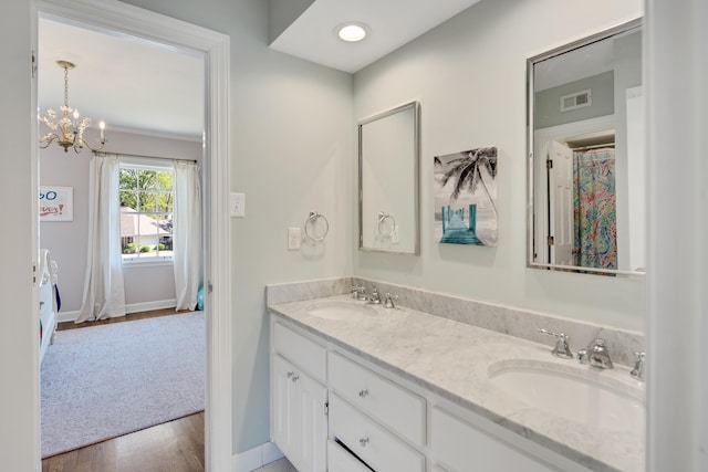 4252 Heatherwood Ln, Memphis, TN 38117 - full bathroom with double vanity, a sink, wood finished floors, and a chandelier