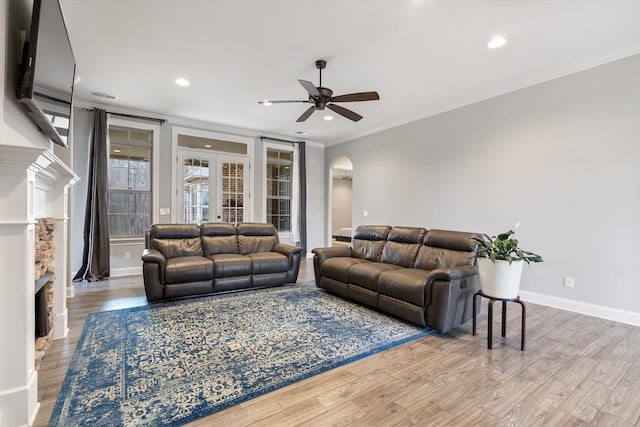 6742 Malone Rd, Olive Branch, MS 38654 - living area featuring a stone fireplace, a ceiling fan, crown molding, arched walkways, and wood finished floors