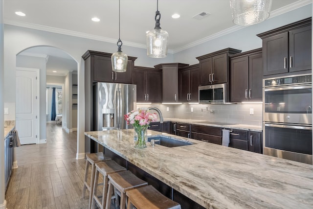 6742 Malone Rd, Olive Branch, MS 38654 - kitchen featuring dark brown cabinetry, arched walkways, visible vents, appliances with stainless steel finishes, and a sink