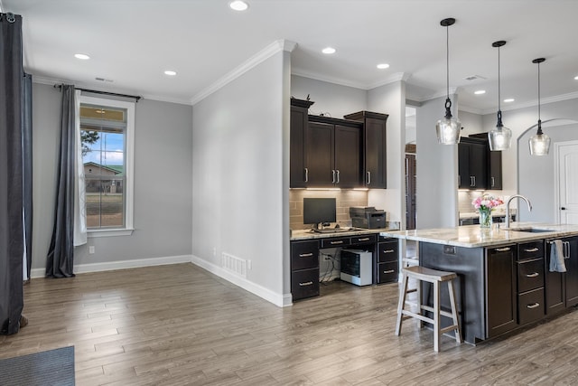 6742 Malone Rd, Olive Branch, MS 38654 - kitchen with tasteful backsplash, light wood-style floors, a kitchen breakfast bar, and a sink
