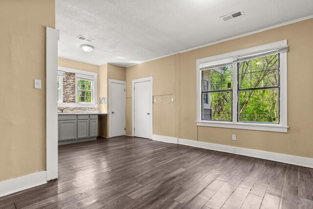 1072 Walk Rd, Memphis, TN 38109 - unfurnished living room featuring a textured ceiling, baseboards, dark wood-style floors, and visible vents