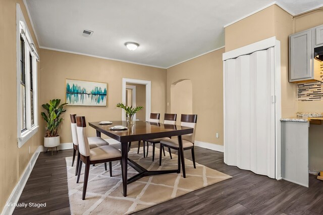 1072 Walk Rd, Memphis, TN 38109 - dining room featuring dark wood-type flooring, arched walkways, and ornamental molding