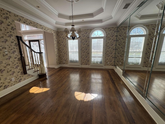 unfurnished dining area with a raised ceiling, an inviting chandelier, wood finished floors, and wallpapered walls