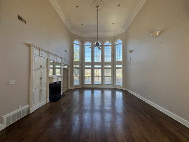 unfurnished living room featuring visible vents, ceiling fan, a fireplace with flush hearth, and dark wood-style floors