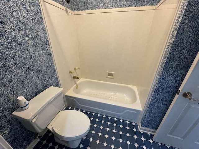 bathroom with tile patterned floors, shower / bathing tub combination, and toilet