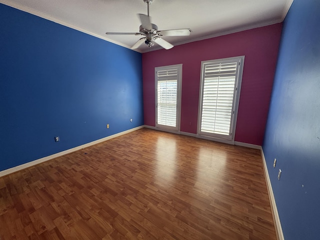 spare room with ornamental molding, baseboards, and wood finished floors