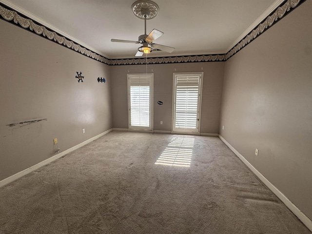 spare room featuring crown molding, light colored carpet, ceiling fan, and baseboards
