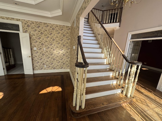 stairs with baseboards, wallpapered walls, an inviting chandelier, ornamental molding, and wood finished floors